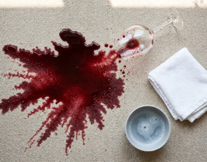 red wine spill on carpet with cleaning cloth nearby