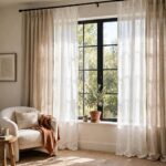 Living room window dressed with layered linen curtains