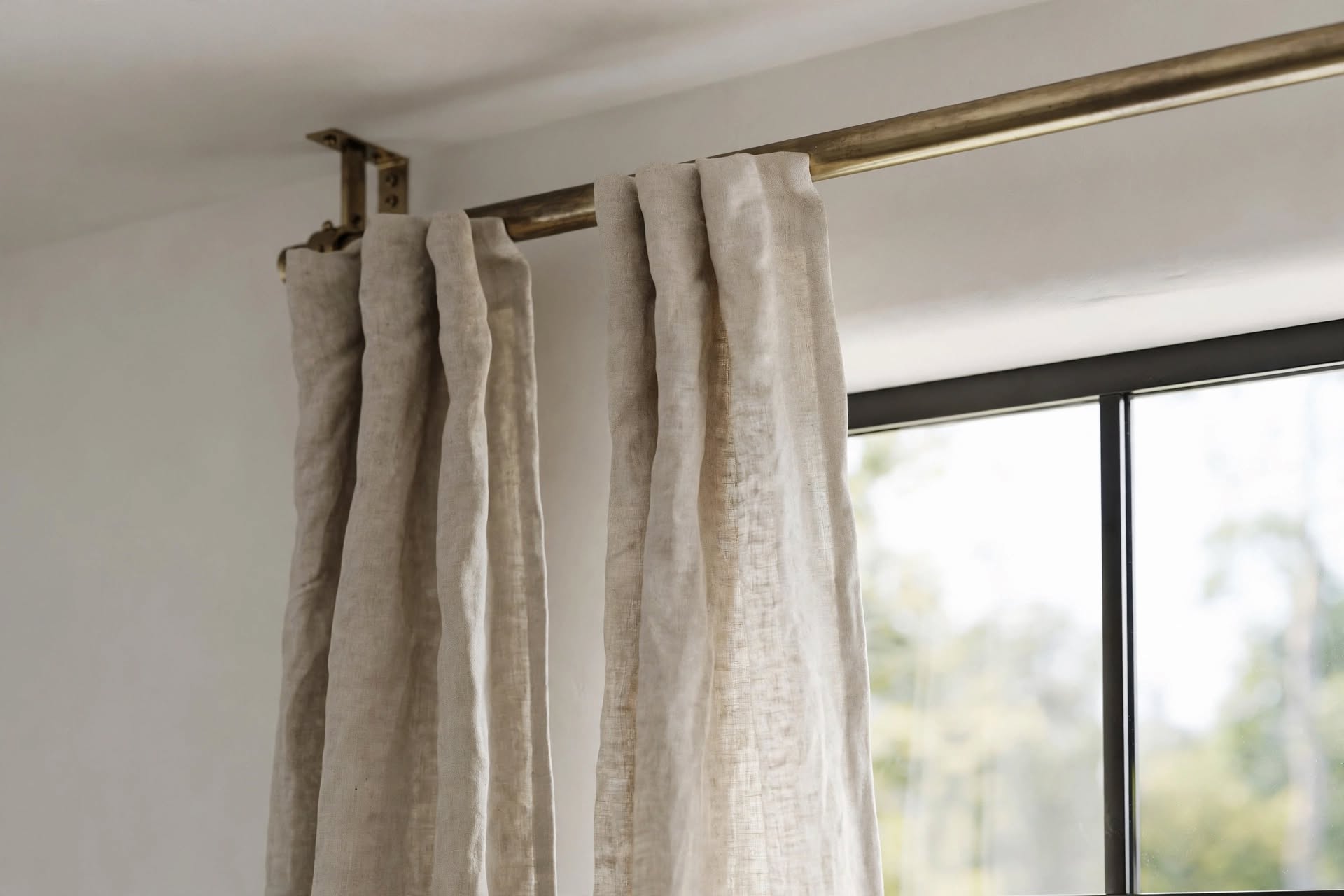 Curtain rod placed close to the ceiling to make a living room window look taller